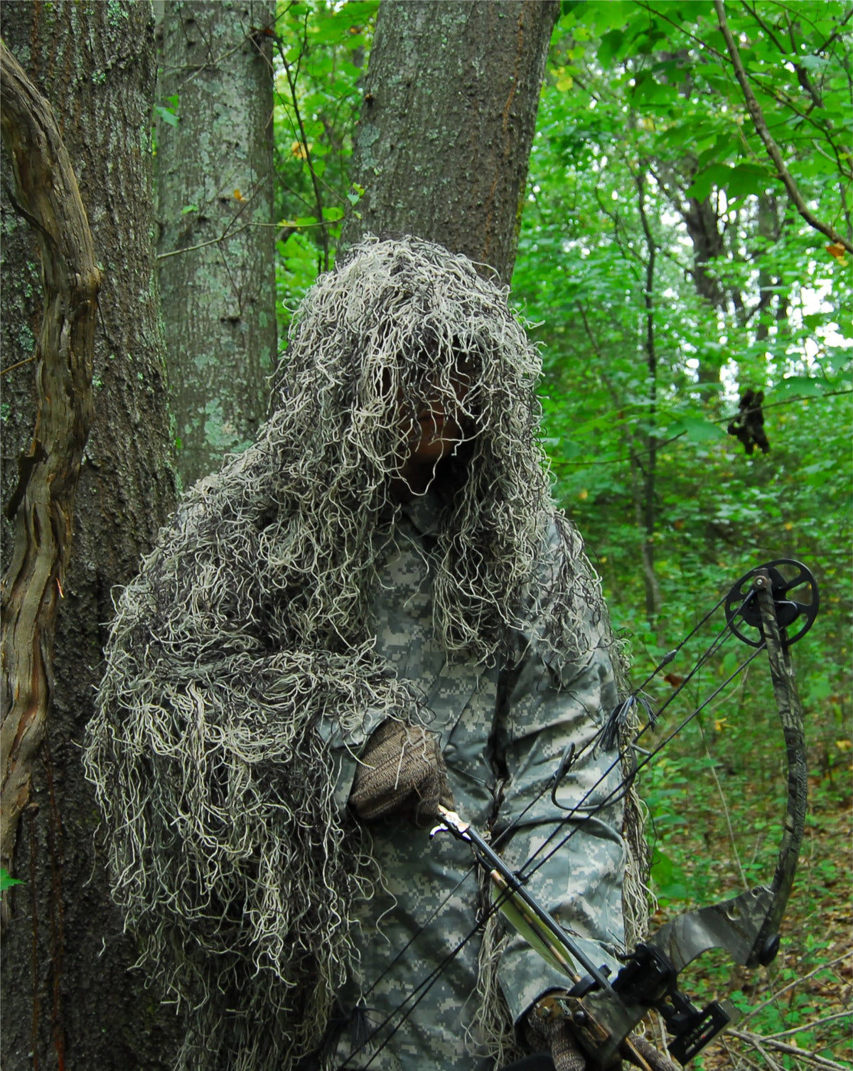 Ultra Light Ghillie Bow Hunting Jacket in Mossy, shown with bow