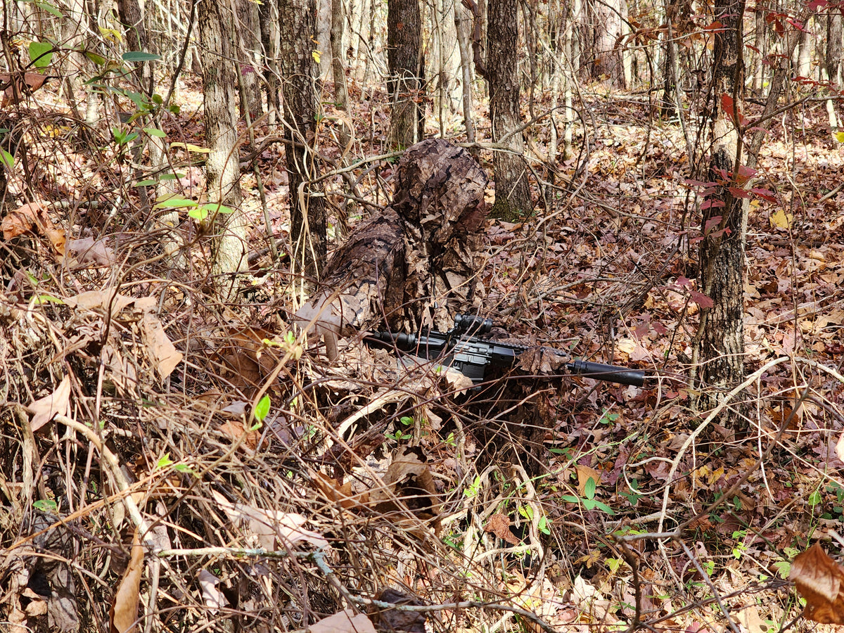 Hunter wearing a Titan 3D Realtree Timber leafy suit in the woods