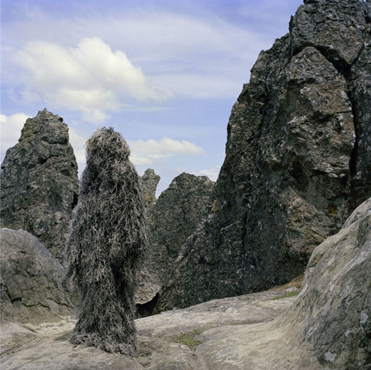Ultra Light Ghillie Poncho in Mossy pattern worn in rocky terrain